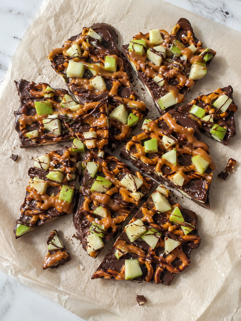 Homemade caramel apple bark with pretzels, Granny Smith apples, chocolate, and caramel broken into irregular pieces.