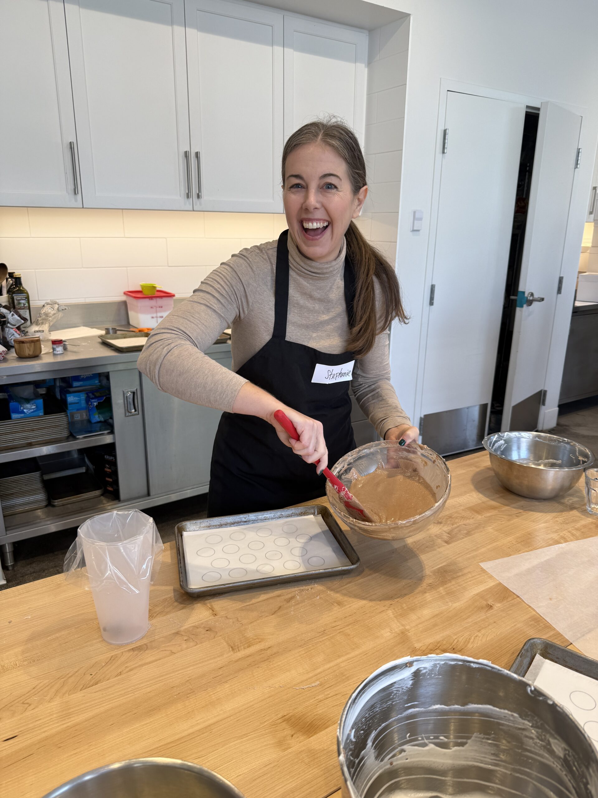 reach wellth founder mixing batter at the sur la table chocolate macaron cooking class in columbus
