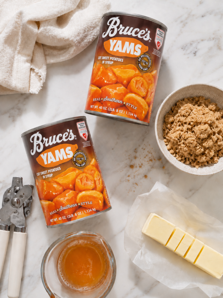 Bruce’s Yams cans with brown sugar, butter, reserved yam syrup, and a can opener on a light marble counter.
