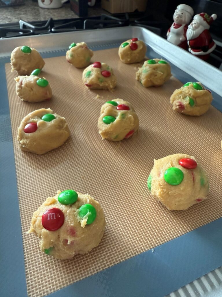 christmas m&m cookie dough rolled into 1.25 in balls topped with extra red and green m&ms
