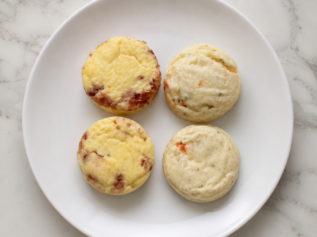 Overhead view of Kirkland Signature bacon and gouda and egg white roasted red pepper egg bites on a white plate.
