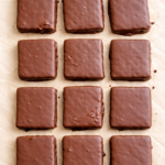 thin mints (chocolate and peppermint coated chocolate gram crackers) on a sheet of parchment paper