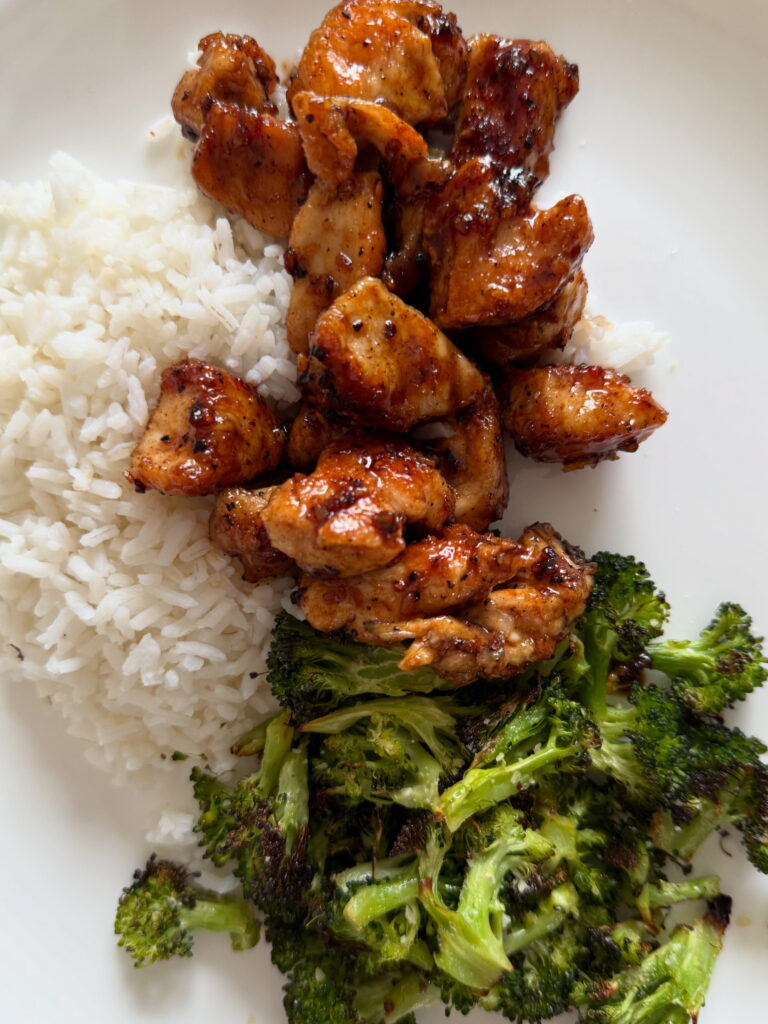 a plate of juicy cooked honey garlic chicken with roasted broccoli and rice