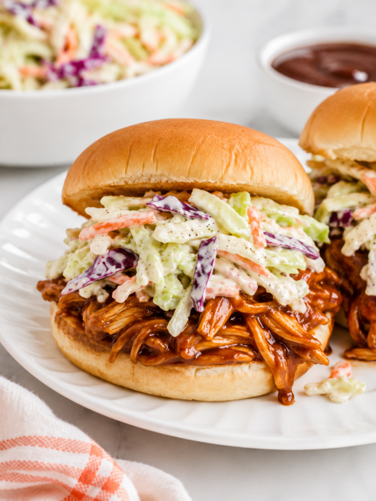 BBQ shredded chicken sandwich with creamy coleslaw made from cabbage, carrots, and homemade dressing.