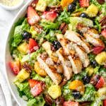 Panera strawberry poppyseed salad recipe with grilled chicken, romaine, strawberries, blueberries, pineapple, mandarin oranges, pecans, and poppyseed dressing.