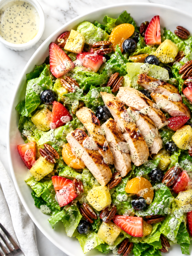 Panera strawberry poppyseed salad recipe with grilled chicken, romaine, strawberries, blueberries, pineapple, mandarin oranges, pecans, and poppyseed dressing.