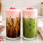 a glass of iced coffee and a glass of iced matcha topped with strawberry cold foam in a bright light kitchen