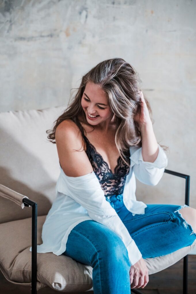 Woman laughing in lace and jeans during a Columbus Ohio boudoir session