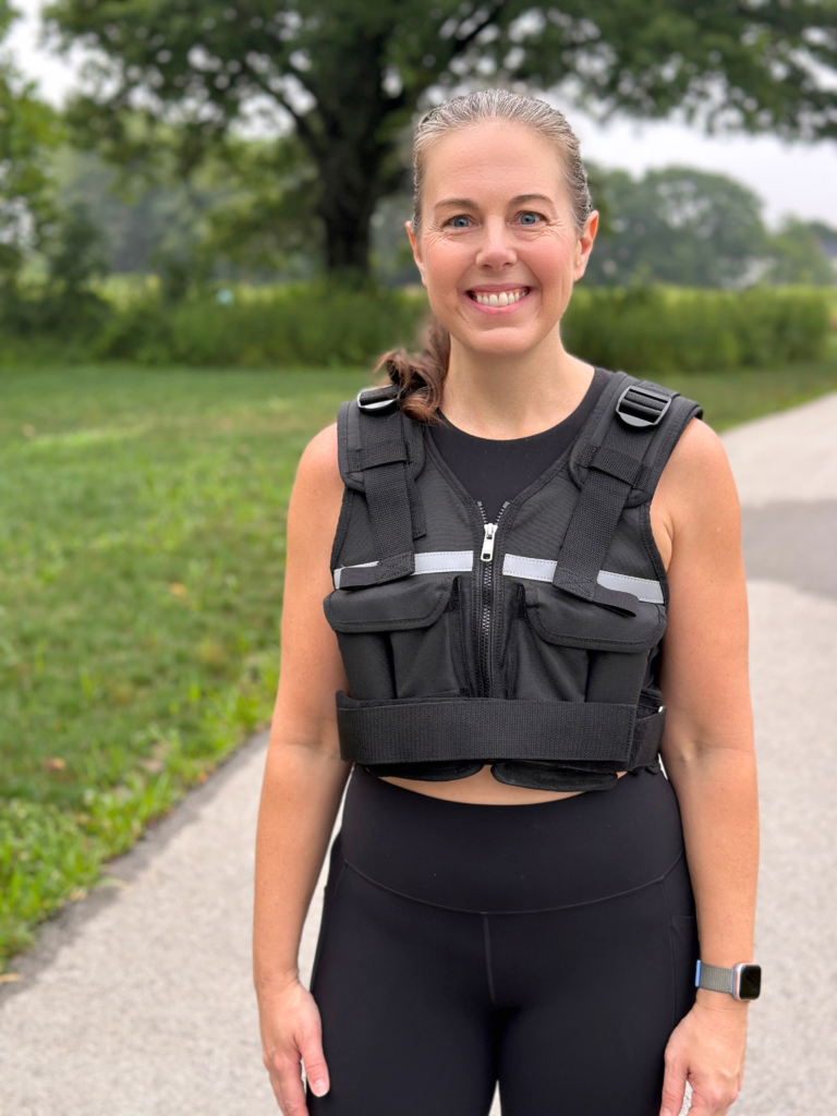 Woman wearing a black weighted vest outdoors before a walk